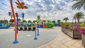 Un parque infantil con diversas estructuras de juego y una zona de descanso con sillones reclinables.