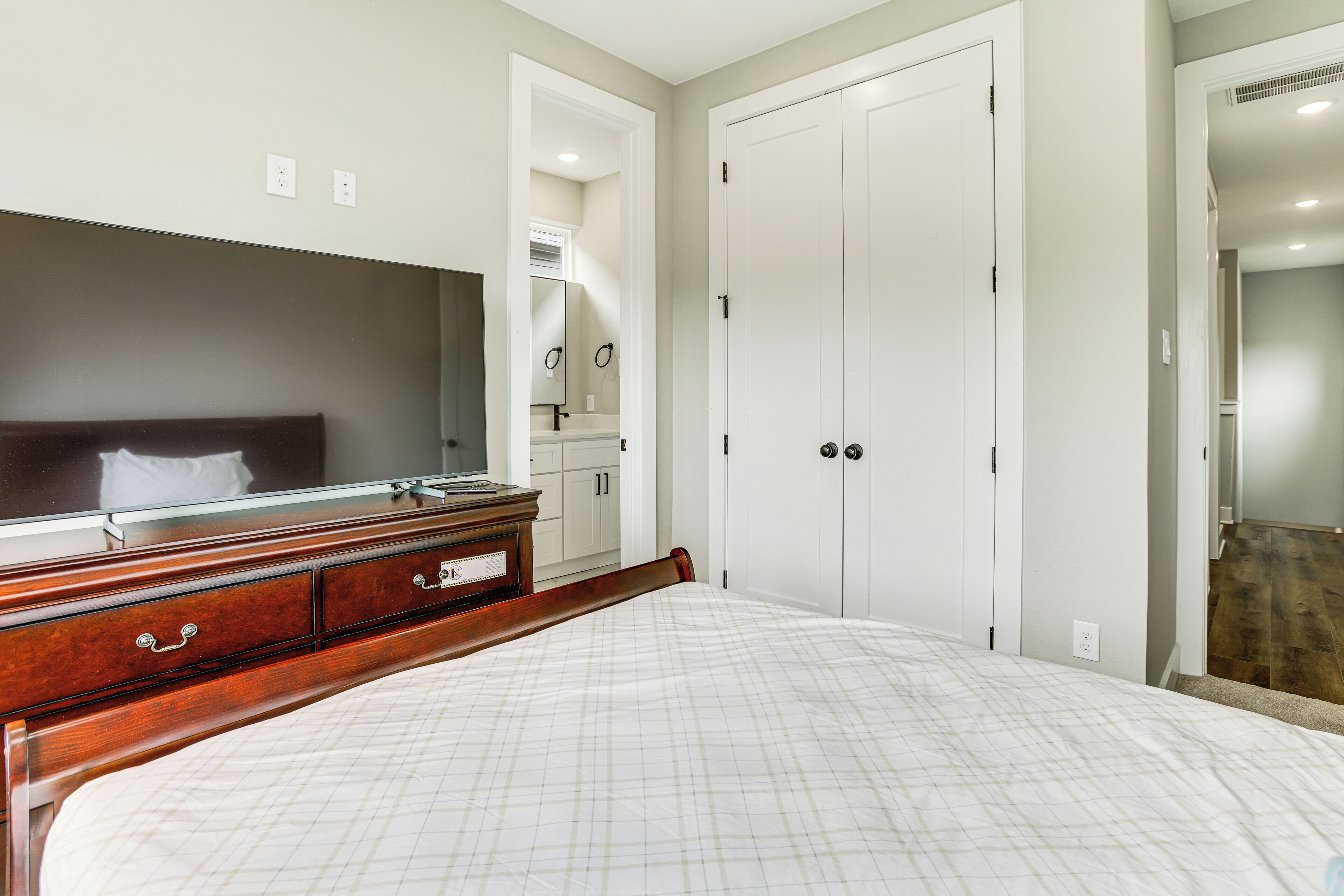 Ein Schlafzimmer mit Bett, Kommode und Kleiderschrank.