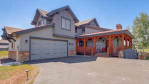 A two-story house with a garage, a covered porch, and a stone foundation. - Grand Elk Golf Club On-site: Mtn-view Home w/ Deck (Granby)