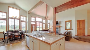 A spacious kitchen with a large island, wooden beams, and large windows. - Grand Elk Golf Club On-site: Mtn-view Home w/ Deck (Granby)
