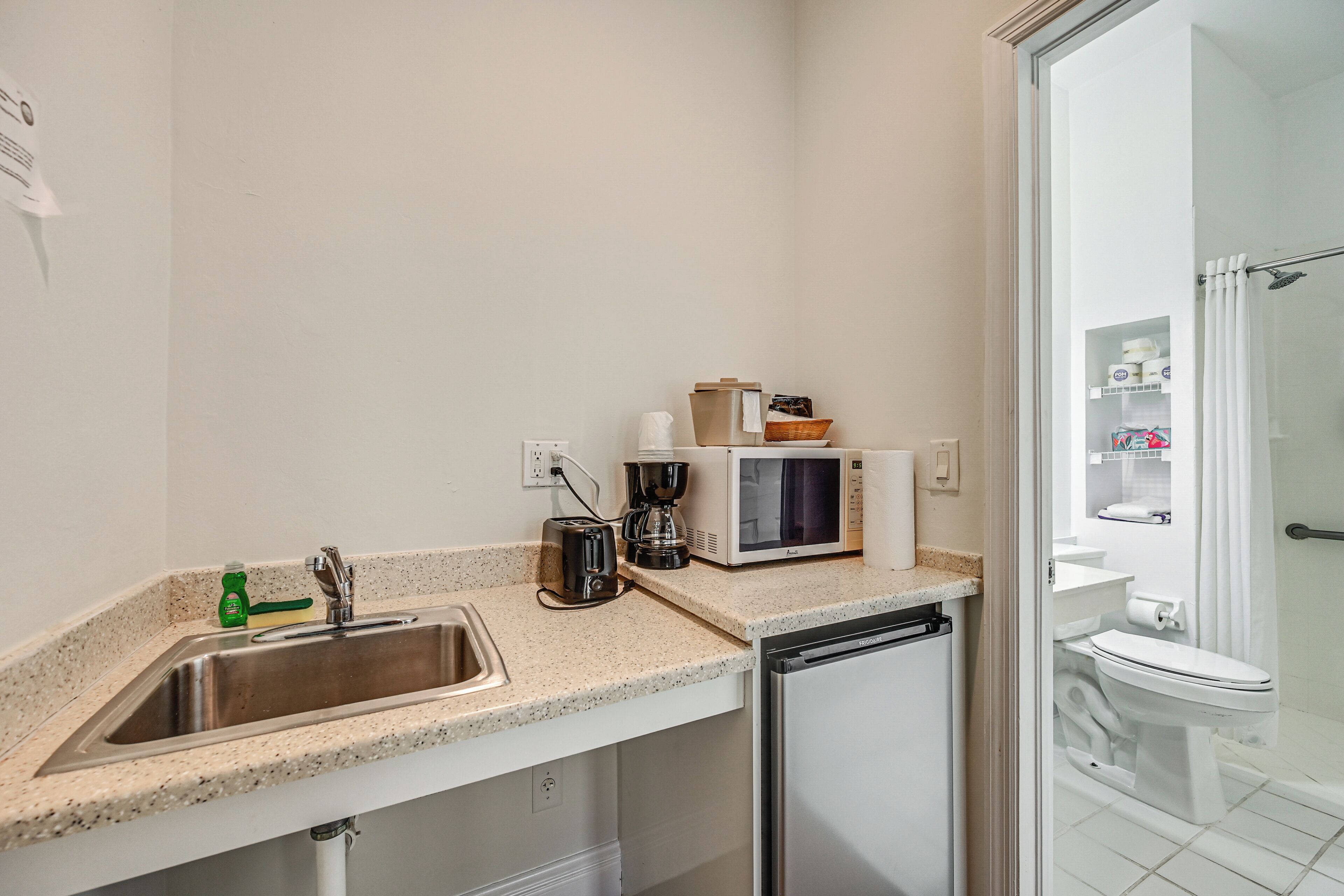 A compact kitchen with a sink, microwave, and dishwasher.