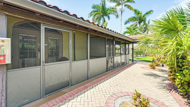 A covered outdoor area with a tiled roof, large windows, and a paved walkway. - Everglades Escape w/ Heated Pool & Marina Access! (Naples)