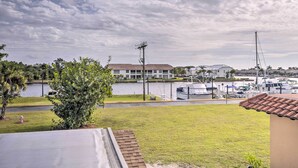 Una marina con barcos, un edificio de techo plano y un área verde con un árbol.