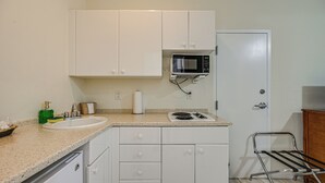 A kitchen with white cabinets, a microwave, a sink, and a stove. - Bring Your Boat: Condo w/ Pool in Naples! (Naples)