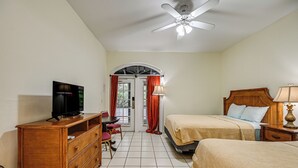 Ein Hotelzimmer mit Bett, Schreibtisch, Fernseher und Kleiderschrank.
