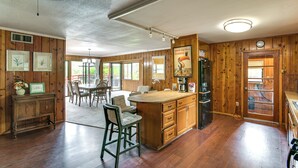 A spacious kitchen with wooden cabinets, a central island, and a dining area with chairs.