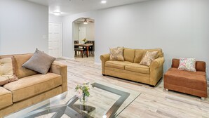 A spacious living room with two sofas, a glass coffee table, and a ceiling fan. - Group Getaway w/ Deck & Yard in Lakeland! (Lakeland)