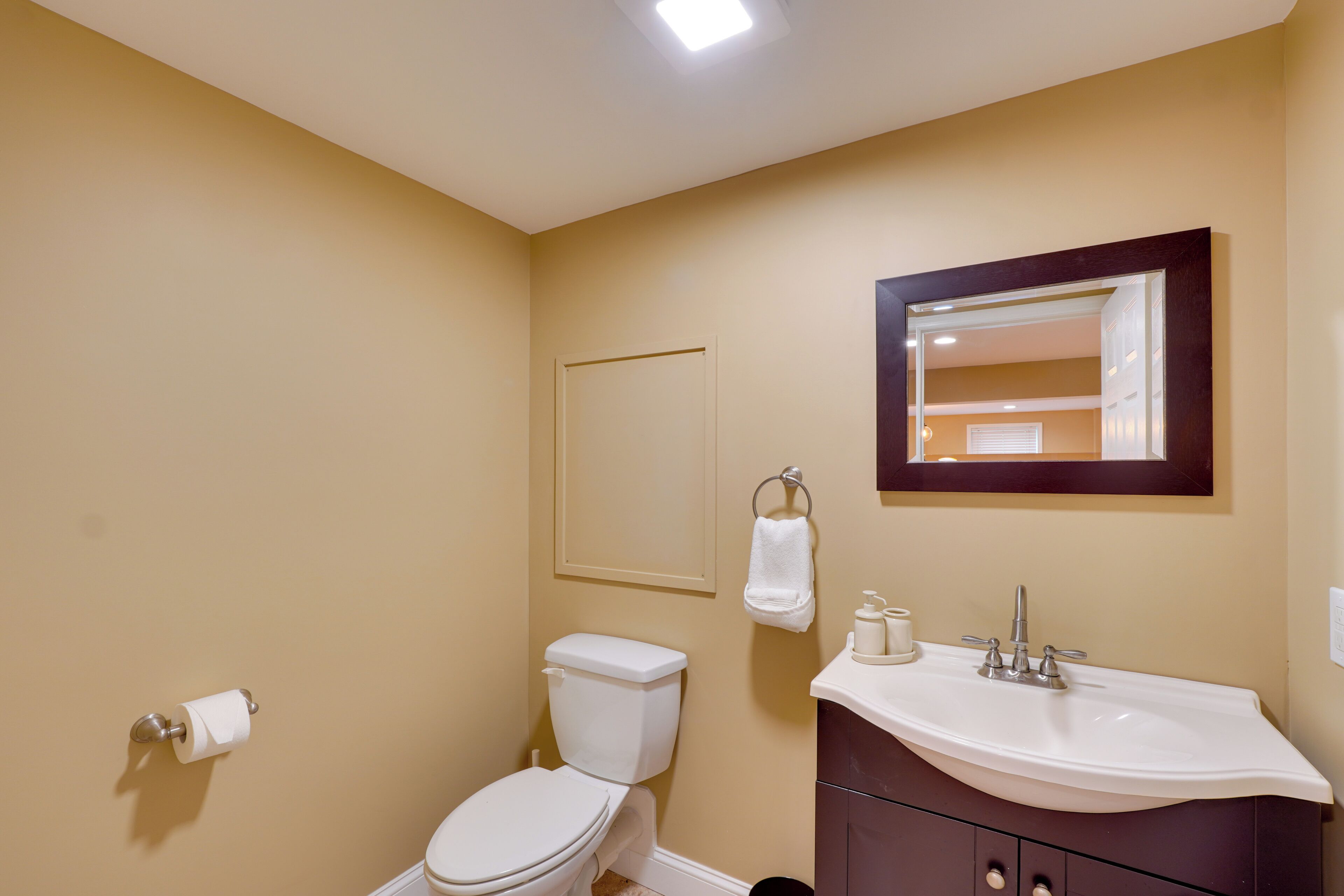 Une salle de bain avec des toilettes, un lavabo et un miroir.