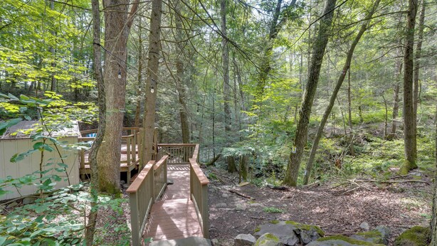 Un pont en bois menant à un chalet situé dans une zone boisée.