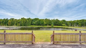 Una terraza de madera con vistas a un lago y un bosque.