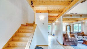 Una escalera de madera que conduce a una sala de estar con un sofá y una mesa de centro.