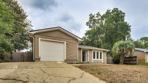 A residential house with a garage, a front porch, and a driveway. - Shop, Dine & Visit Uwf: Pensacola Home w/ Yard! (Pensacola)