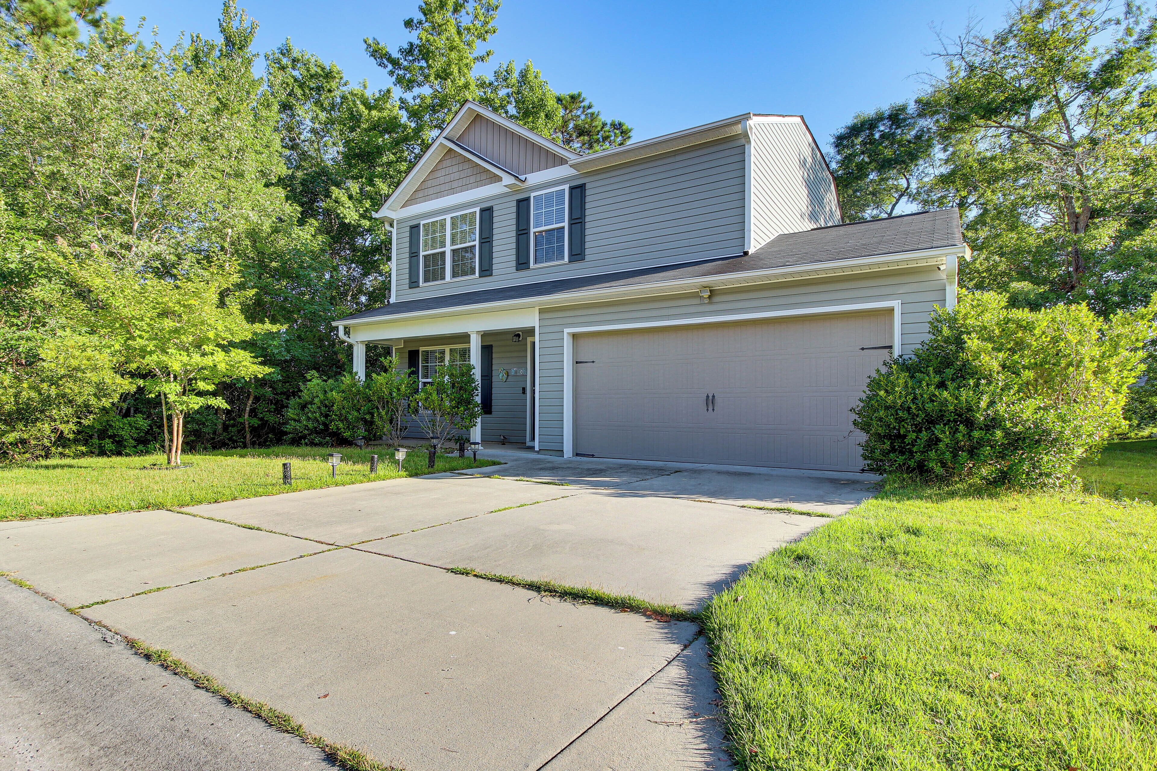 A two-story house with a garage, a front porch, and a driveway.