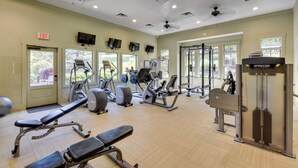 A gym with various exercise equipment, large windows, and an exit sign. - Community Perks: Mountain-view Condo in Toccoa! (Toccoa)