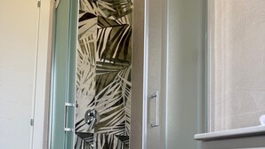 A bathroom with a shower area, a toilet, and a sink.