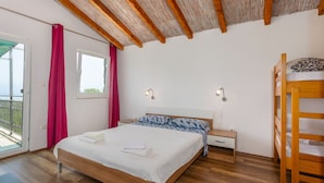 A bedroom with a wooden bed, a nightstand, a bedside table, a bunk bed, a window with curtains, and a balcony. - Villa Risika 1 with pool island Krk by Villas Guid (Risika)
