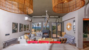 Una sala moderna con una cama grande, una chimenea y vistas al exterior.