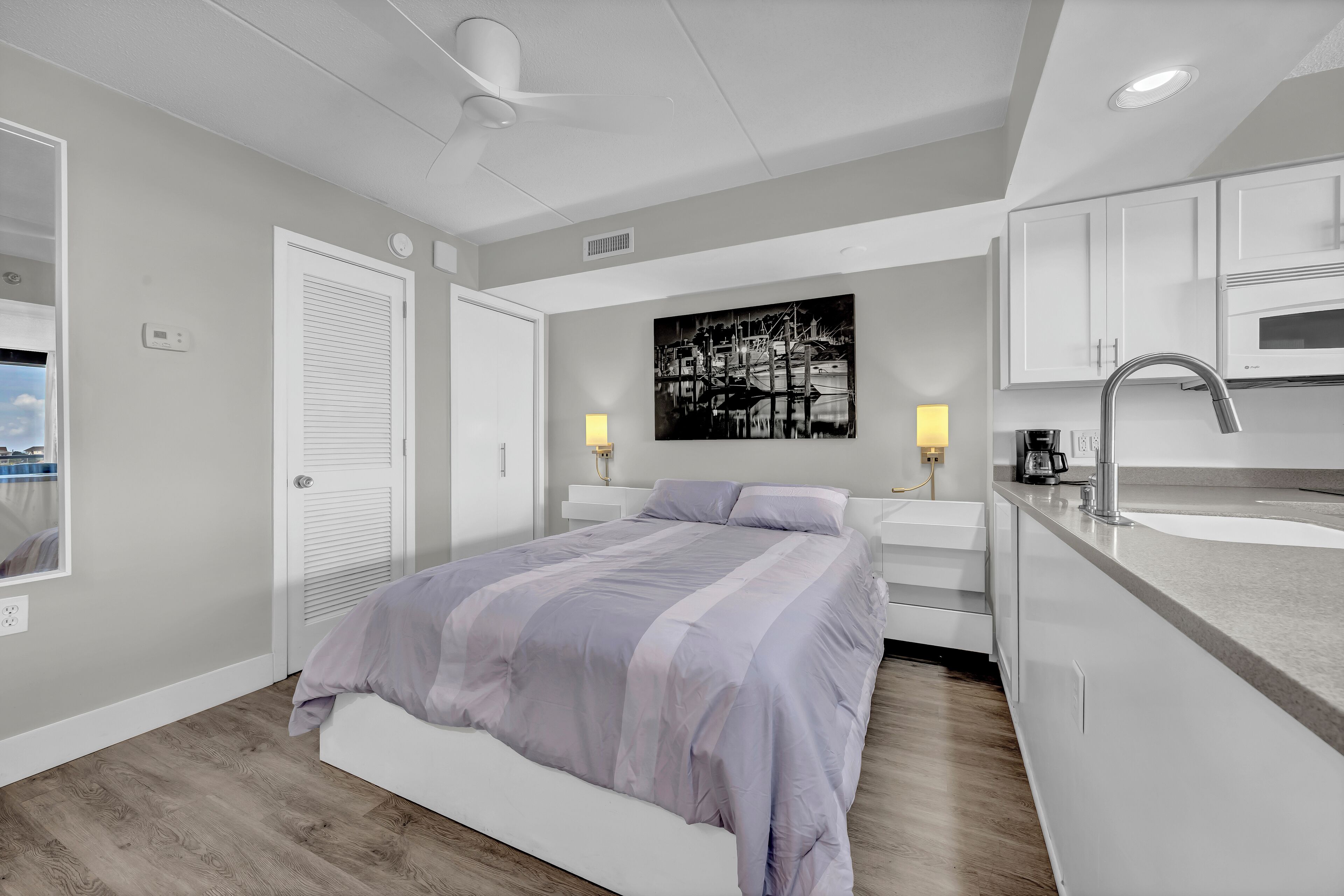 Une chambre à coucher moderne avec un lit, des lampes de chevet et une vue sur la ville.