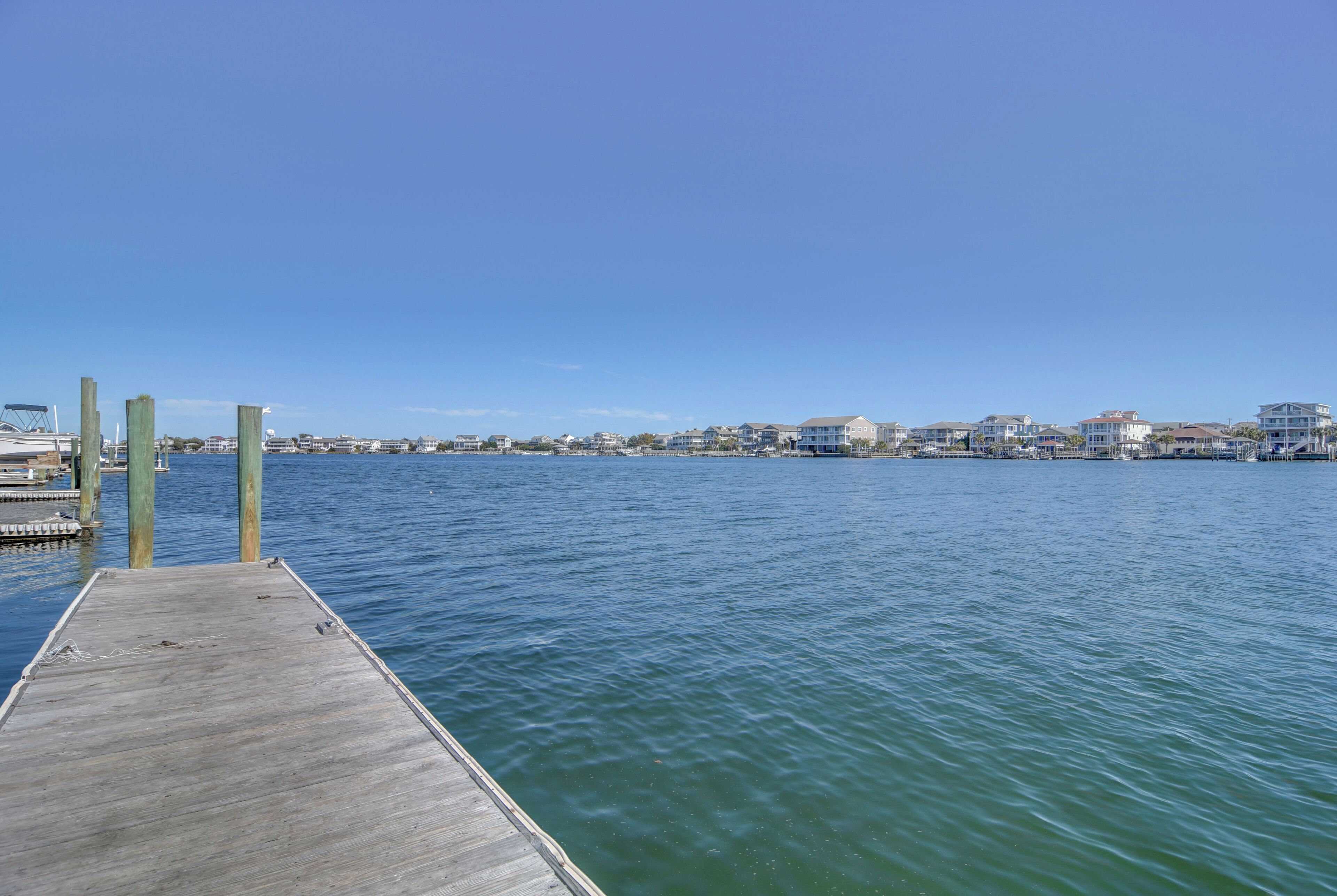 Un muelle de madera que se adentra en aguas tranquilas bajo un cielo despejado.