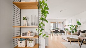 A modern living room with a sofa, coffee table, and a dining area with chairs. - City Apartment | Modern & Spacious (Bergen)