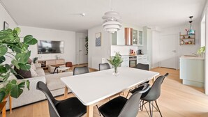 A modern living space with a dining area, kitchen, and seating area. - City Apartment | Modern & Spacious (Bergen)