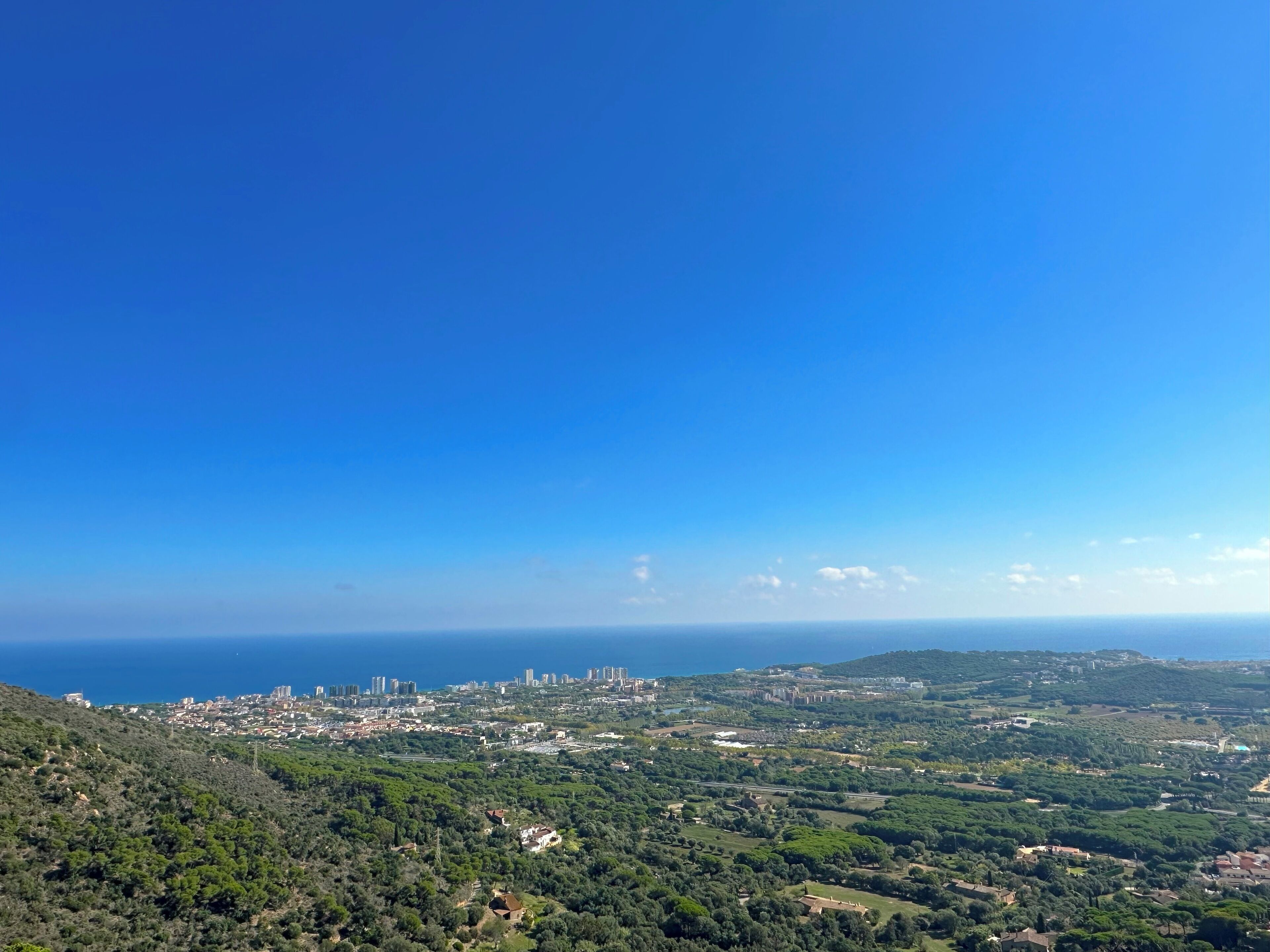 Une vue panoramique d’une ville côtière, où se mêlent des paysages urbains et naturels.