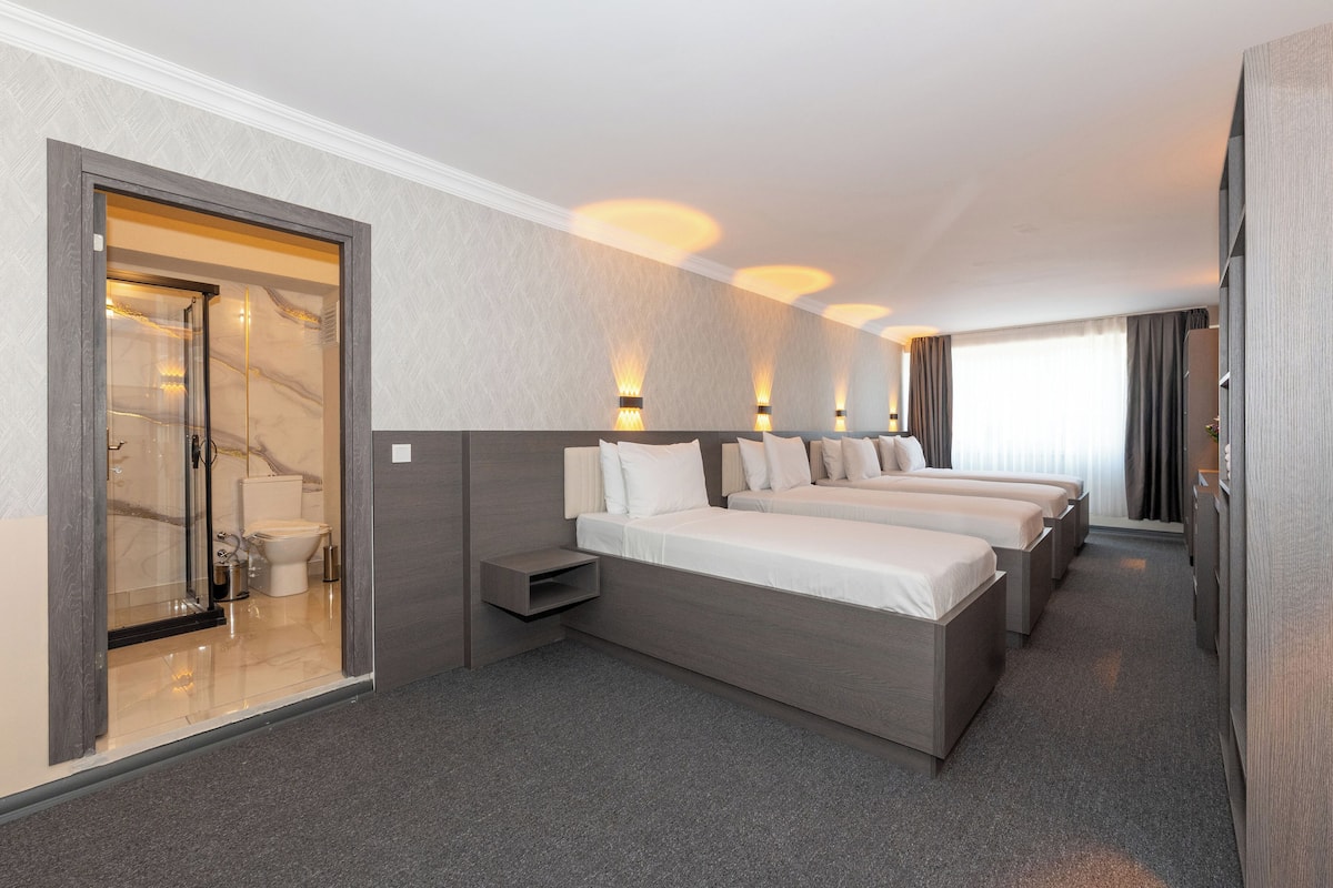 Quarto de hotel com cama grande, banheiro separado e vista para a cidade.