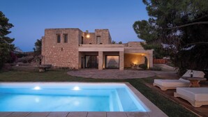 A stone house with a swimming pool and outdoor seating.