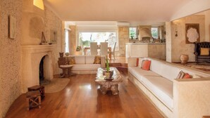 A spacious living room with a fireplace, wooden furniture, and a view to the outside.