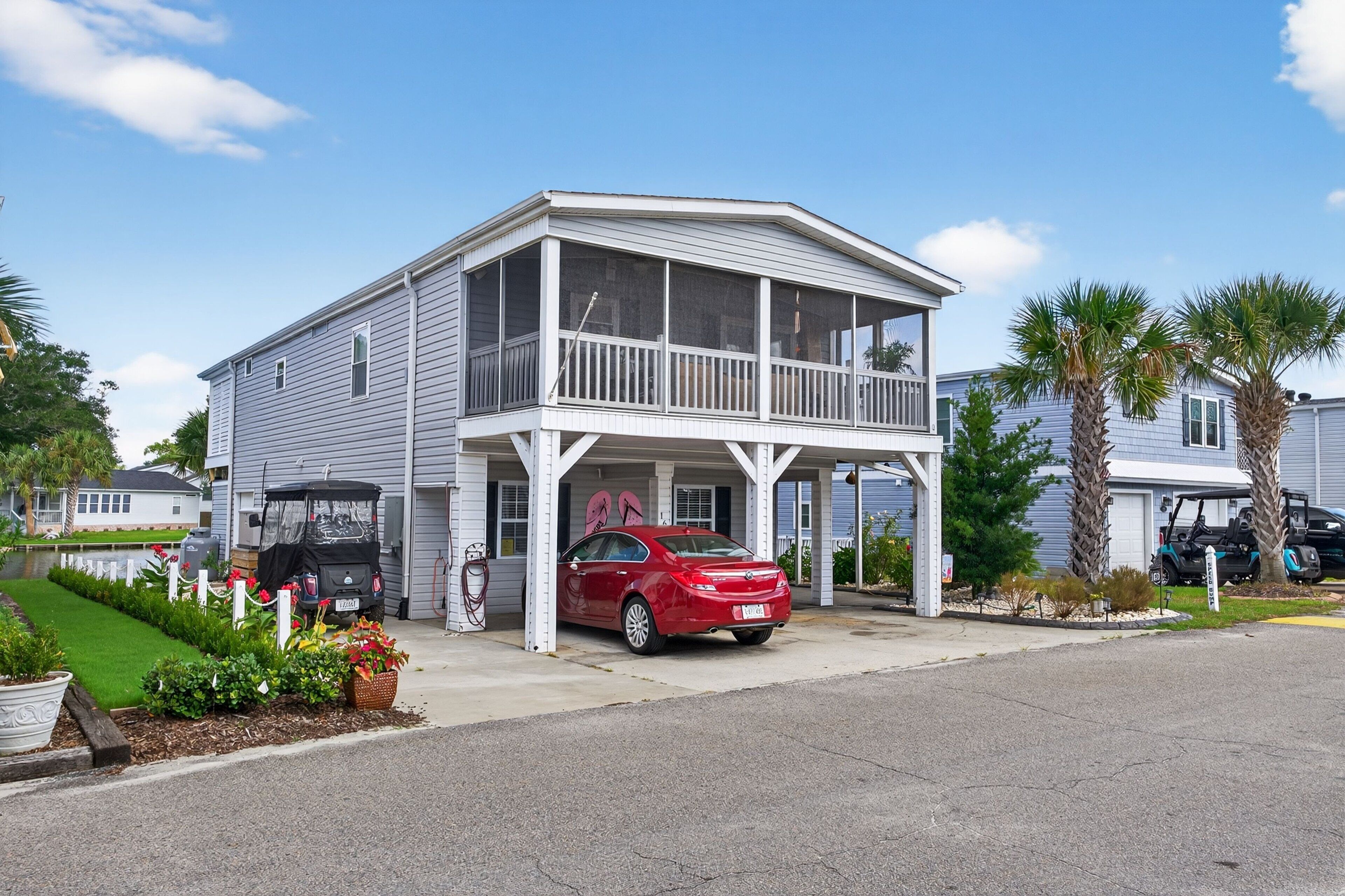 A two-story building with a covered porch and a car parked in front.