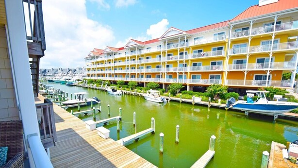 Un hôtel situé au bord de l’eau, doté de nombreux balcons, d’un quai et d’une marina avec des bateaux.