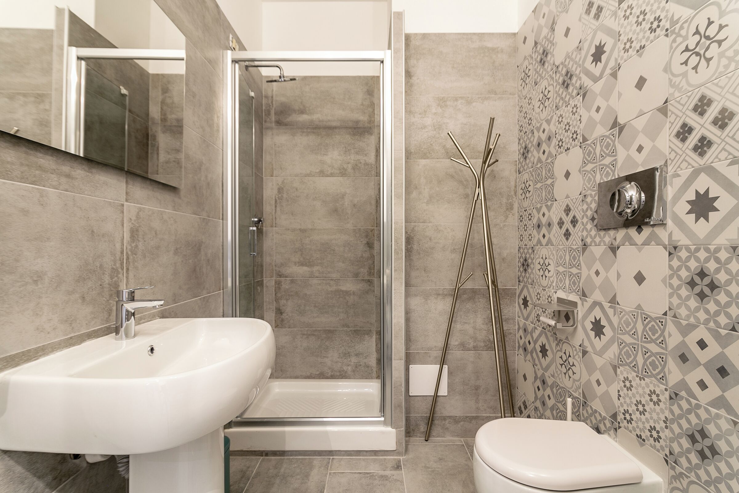 A bathroom with a shower, sink, and toilet.