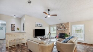 A spacious living room with two sofas, a TV, and a fireplace. - Space & Sunshine Retreat/3BR Near NASA & NRG (Houston)