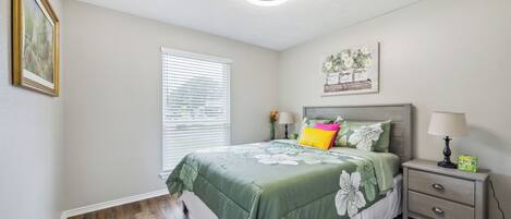 A bedroom with a bed, nightstand, and a ceiling fan.