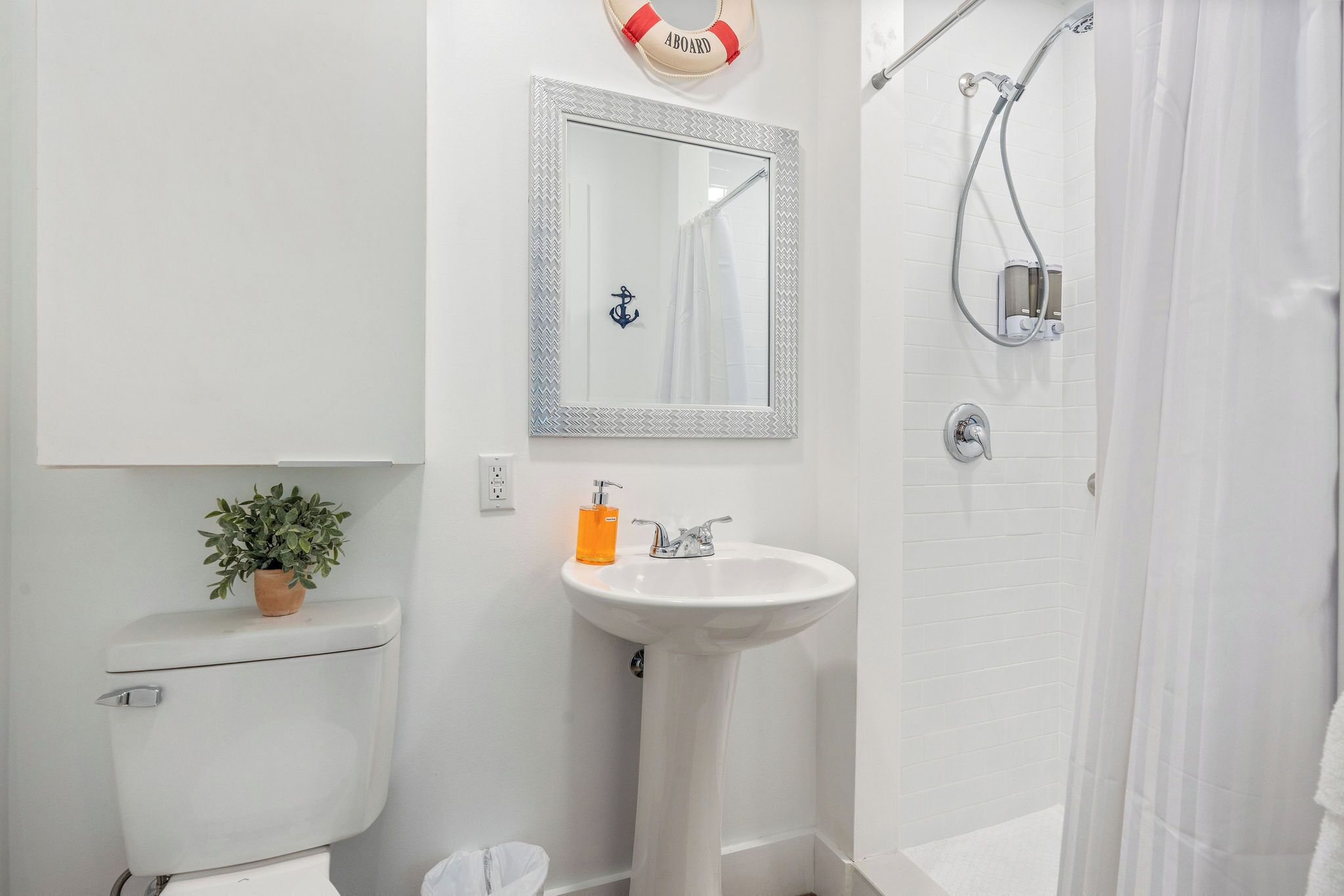 A bathroom with a toilet, sink, and shower.