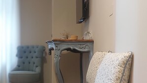 Un salón con un sofá gris, un sillón azul y suelo de madera.