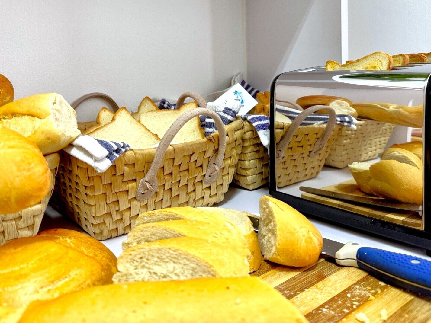 Una cucina con cesti di vimini pieni di pane, un tagliere e un coltello.