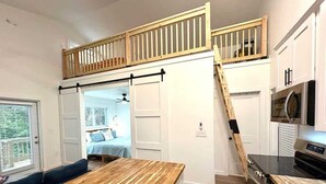 A kitchen with a wooden countertop, a sliding door, a microwave, and a stove. - 120 Falkirk Small Pet Friendly Cottage near Beach (Fort Myers Beach)