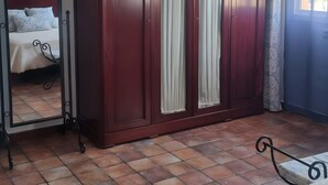 A room with a large wardrobe, a bed with a headboard, and a window with curtains. - Country House 'Casa Rural Valle' with Mountain View, Private Pool and Air Conditioning (La puebla de los infantes)