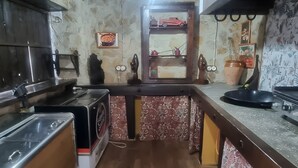 A kitchen with a wooden floor, a stove, a sink, and a shelf with a car model. - Country House 'Casa Rural Valle' with Mountain View, Private Pool and Air Conditioning (La puebla de los infantes)