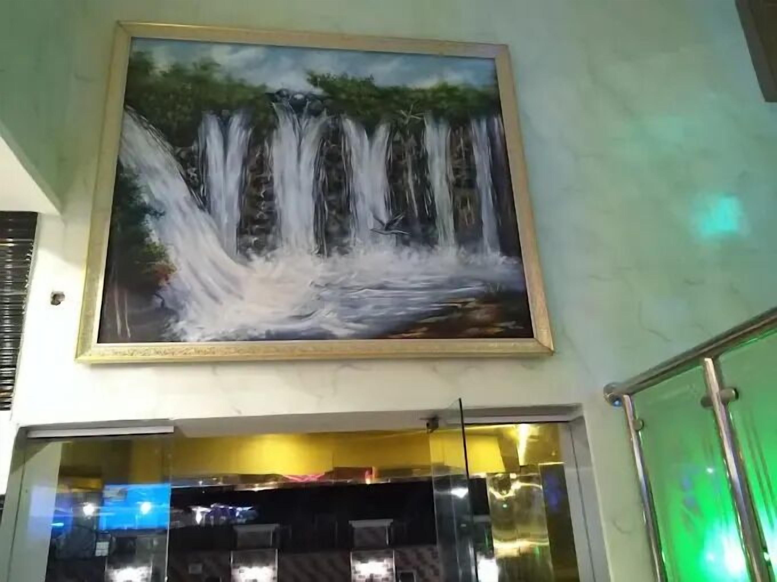 A painting of a waterfall on a wall.
