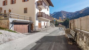 A two-story building with a garage, a stone wall, and a wooden fence.
