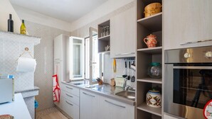 A modern kitchen with white cabinets, a stainless steel sink, and a built-in oven. - Villa Rita Ostuni with pool by Rentbeat  (Ostuni)