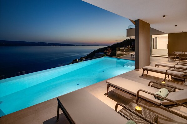A modern infinity pool with a view of the sea at dusk. - Villa Angelus – Your Luxurious Retreat near the Sea (Celina)