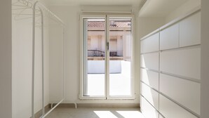 Ein schmales Zimmer mit einer Schiebeglasdoor zu einem Balkon.