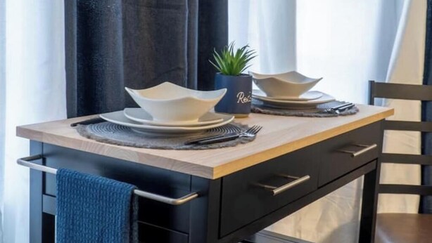 A dining table set with plates, bowls, and cutlery, accompanied by a small potted plant and a decorative item with the word "Relax". - Perfect Location! All include Tampa Private Suite (Tampa)