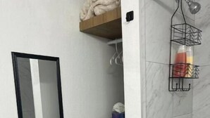 A bathroom with a mirror, a towel rack, a shower, and a waste bin. - Perfect Location! All include Tampa Private Suite (Tampa)
