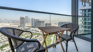 Un balcon avec une table et des chaises, offrant une vue sur la ville.