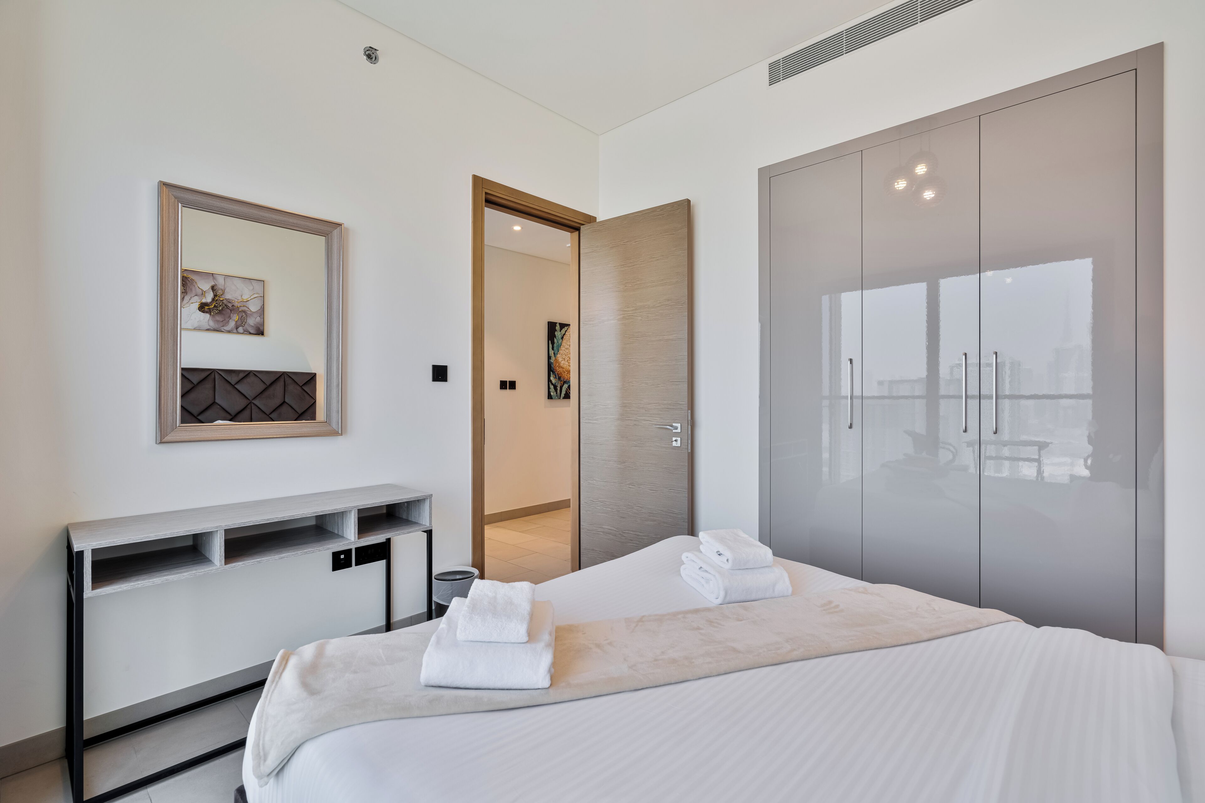 Ein modernes Hotelzimmer mit Bett, Schreibtisch und Kleiderschrank.