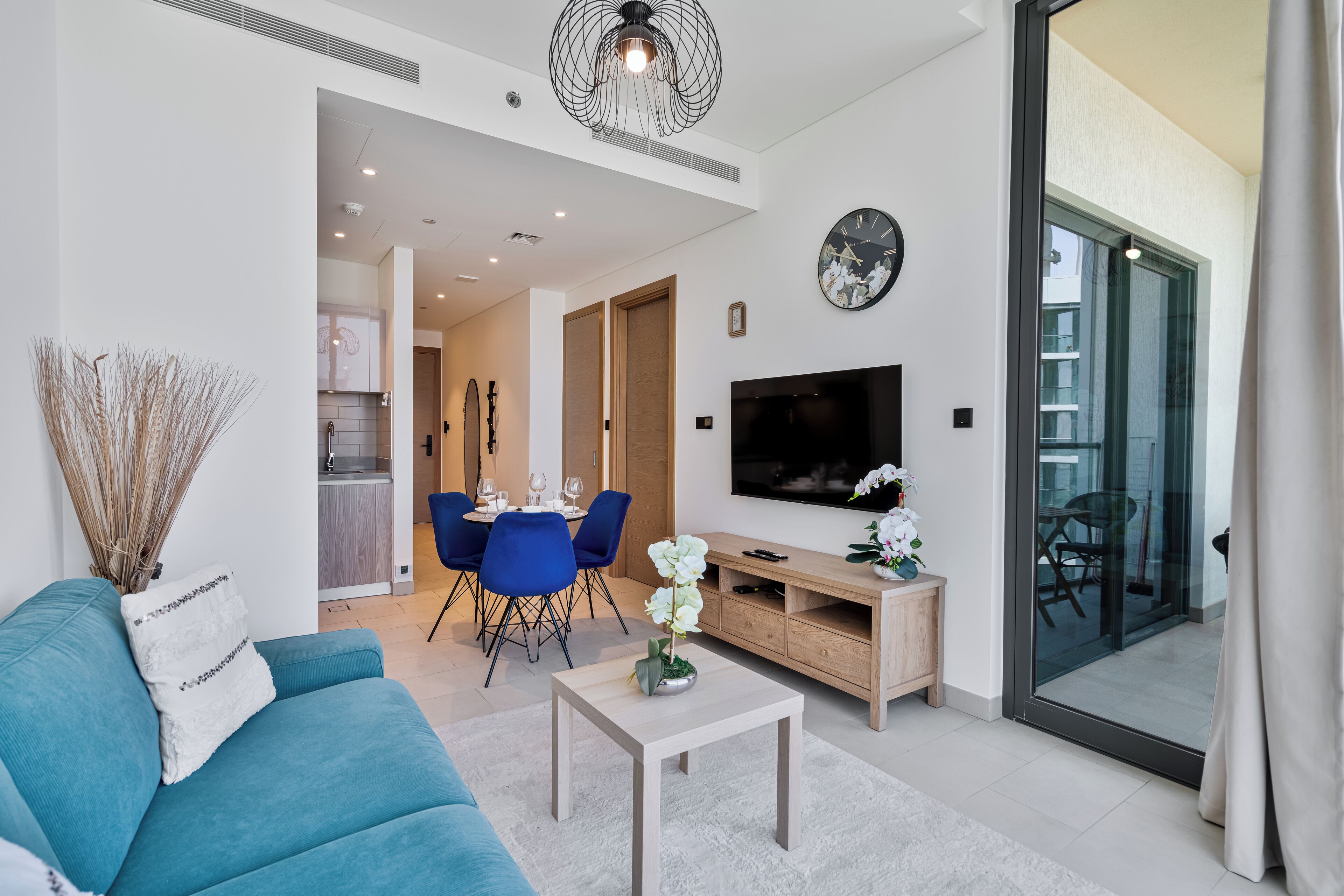 Ein modernes Wohnzimmer mit Sofa, Couchtisch, Fernseher und Essbereich.